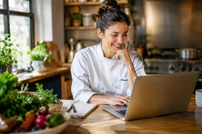 Chef sending a client message from a tablet in a kitchen